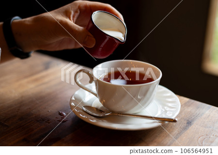 Pouring milk into tea 106564951