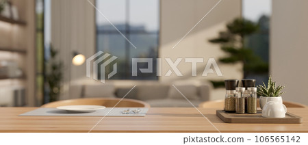 A seasoning bottle tray and a plate and cutlery on a placemat on a hardwood dining table A seasoning bottle tray and a plate and cutlery on a placemat on a hardwood dining table 106565142