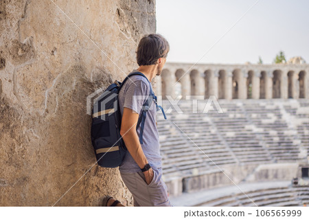 Man tourist explores Aspendos Ancient City. Aspendos acropolis city ruins, cisterns, aqueducts and old temple. Aspendos Antalya Turkey. turkiye Man tourist explores Aspendos Ancient City. Aspendos acropolis city ruins, cisterns, aqueducts and old temple. Aspendos Antalya Turkey. turkiye 106565999