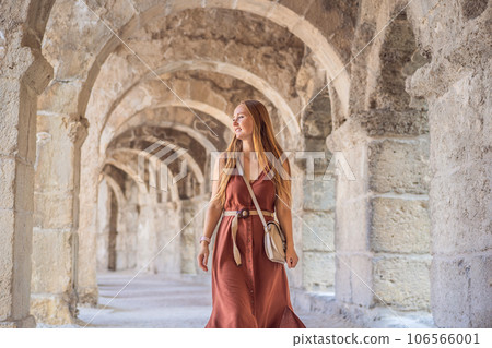Woman tourist explores Aspendos Ancient City. Aspendos acropolis city ruins, cisterns, aqueducts and old temple. Aspendos Antalya Turkey. turkiye Woman tourist explores Aspendos Ancient City. Aspendos acropolis city ruins, cisterns, aqueducts and old temple. Aspendos Antalya Turkey. turkiye 106566001