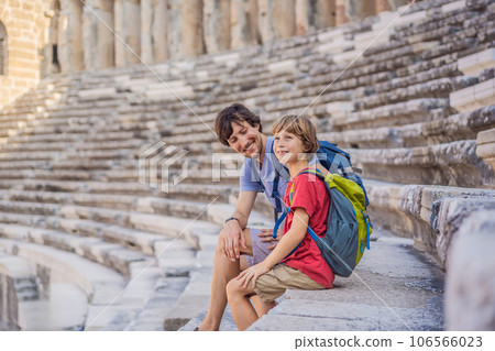Father and son tourists explores Aspendos Ancient City. Traveling with kids concept. Aspendos acropolis city ruins, cisterns, aqueducts and old temple. Aspendos Antalya Turkey. turkiye Father and son tourists explores Aspendos Ancient City. Traveling with kids concept. Aspendos acropolis city ruins, cisterns, aqueducts and old temple. Aspendos Antalya Turkey. turkiye 106566023