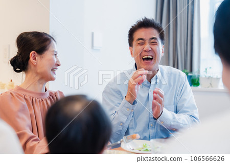 An elderly couple enjoying a meal with their grandchildren 106566626