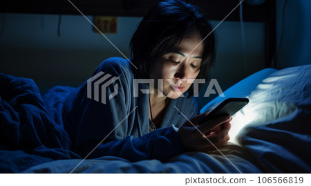 日本女性晚上在臥室使用智能手機 106566819