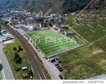 Aerial view of a big sports and soccer football field in a village near Winningen at the moselle river in Germany Aerial view of a big sports and soccer football field in a village near Winningen at the moselle river in Germany 106567719
