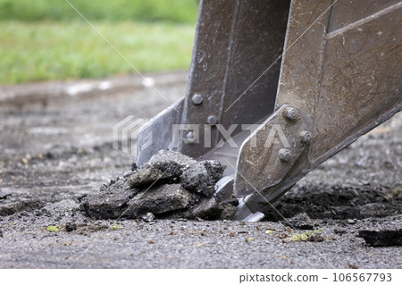 Excavator removing old asphalt for paving work Excavator removing old asphalt for paving work 106567793