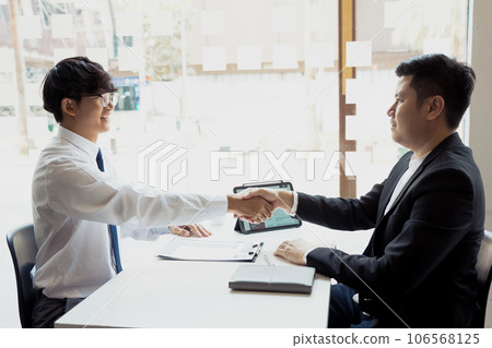 Manager and employee interview concept with handshake after talking about contract signing. 106568125