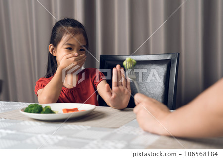 Little cute kid girl refusing to eat healthy vegetables. Children do not like to eat vegetables. 106568184