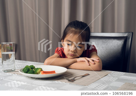 Little cute kid girl refusing to eat healthy vegetables. Children do not like to eat vegetables. Little cute kid girl refusing to eat healthy vegetables. Children do not like to eat vegetables. 106568196