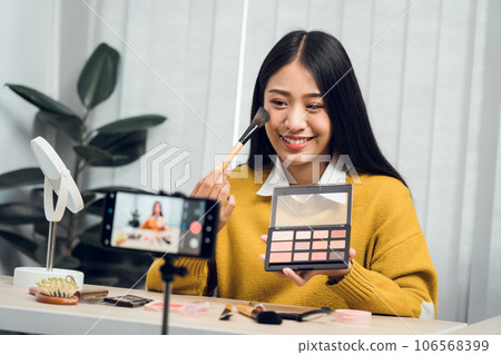 Young Asian beauty blogger is showcasing cosmetic products as well as tutorials on how to apply and record makeup tutorials on social media networks. 106568399
