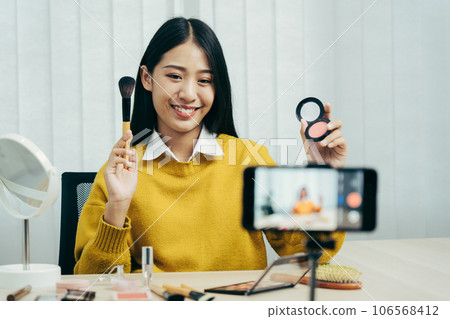 Young Asian beauty blogger is showcasing cosmetic products as well as tutorials on how to apply and record makeup tutorials on social media networks. 106568412