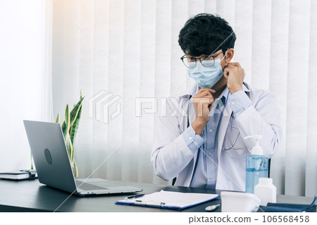 Asian male doctor wearing a mask at his office. 106568458