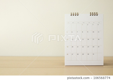 Calendar page close up on wood table with white wall background business planning appointment meeting concept Calendar page close up on wood table with white wall background business planning appointment meeting concept 106568774