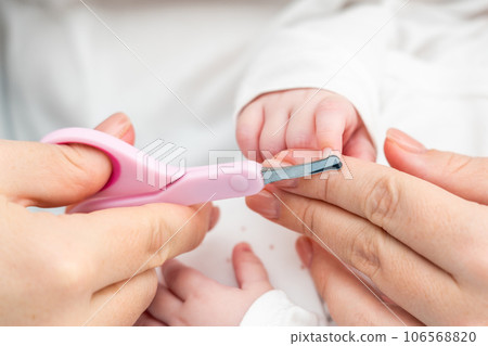 Safety in trimming newborn nails. Concept of detailed infant nail grooming 106568820