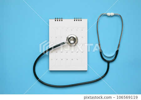 Stethoscope with calendar page date on blue background doctor appointment medical concept Stethoscope with calendar page date on blue background doctor appointment medical concept 106569119