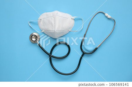 Stethoscope medical equipment with KN95 face mask on blue background covid-19 Coronavirus prevention healthcare concept Stethoscope medical equipment with KN95 face mask on blue background covid-19 Coronavirus prevention healthcare concept 106569141
