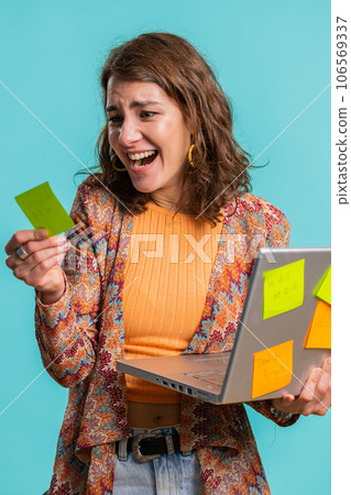 Exhausted freelancer woman with pasted sticker notes use laptop confused by big routine work loading 106569337