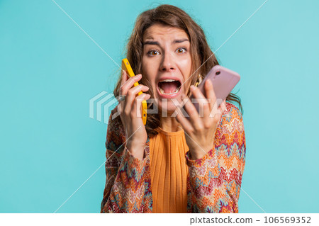 Irritated stressed business woman talking on two mobile phones having conversation conflict quarrel Irritated stressed business woman talking on two mobile phones having conversation conflict quarrel 106569352