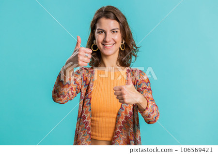 Young woman raises thumbs up agrees or gives positive reply recommends advertisement likes good idea Young woman raises thumbs up agrees or gives positive reply recommends advertisement likes good idea 106569421