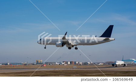 Side view of an airplane landing against a blue sky. Widescreen.  106569649
