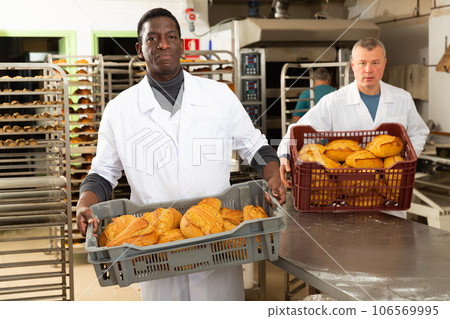 Bakers arranging bakery products 106569995