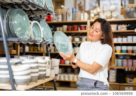 Young woman choosing new dishware at store 106569998