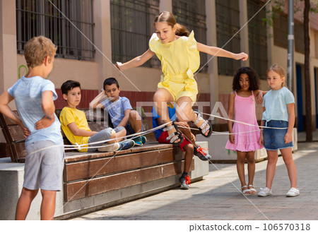 Happy smiling little friends playing with chinese jumping rope Happy smiling little friends playing with chinese jumping rope 106570318