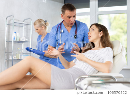 Focused physician talking to young female patient in clinic Focused physician talking to young female patient in clinic 106570322