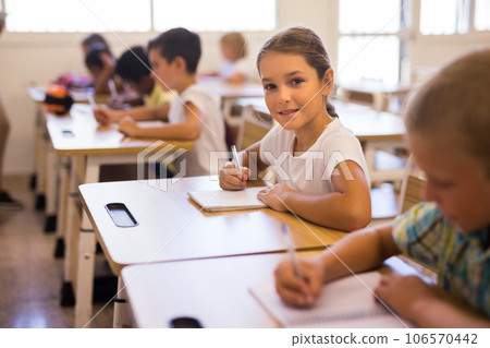 Portrait of girl who is posing at the desk in classroom elementary school 106570442