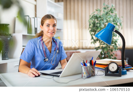 Female doctor sitting at desk in office 106570510