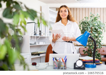 Female secretary standing beside her workplace Female secretary standing beside her workplace 106570516