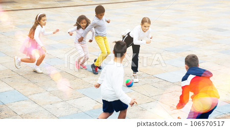 Group of active schoolchildren playing football at summer day Group of active schoolchildren playing football at summer day 106570517