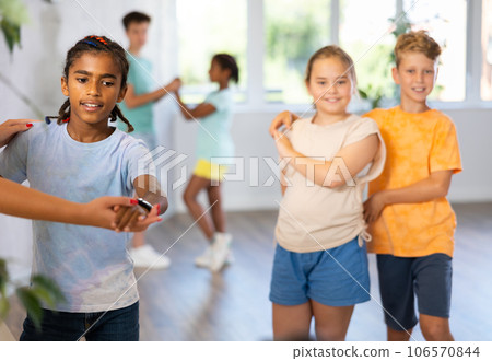 Active preteen children practicing Ballroom dances in pairs in training hall 106570844
