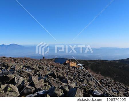 View of Tateshina summit hut and mountains from near the summit of Mt. Tateshina in Chino City, Nagano Prefecture 106570905