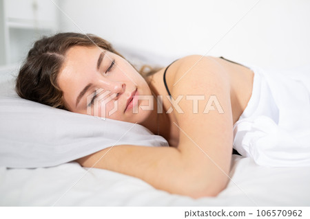 Girl sleeping on white bedlinen in bed at home 106570962