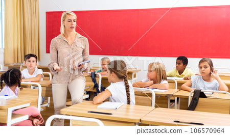 Woman teacher talking with pupils at classroom Woman teacher talking with pupils at classroom 106570964