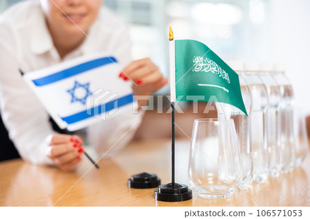 Flags of Israel and Saudi Arabia stand on negotiating table in office 106571053