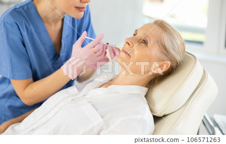 Woman applying rejuvenating treatments by doctor. 106571263