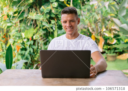 Portrait of a cheerful caucasian man having a video call on his laptop. 106571318