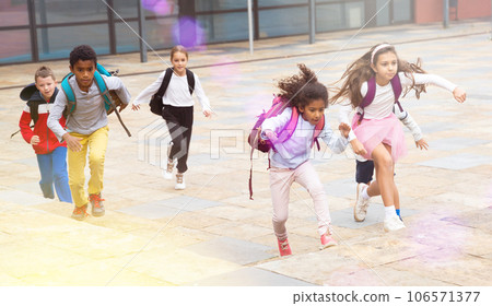 Team of positive schoolchildren running in race in the street 106571377