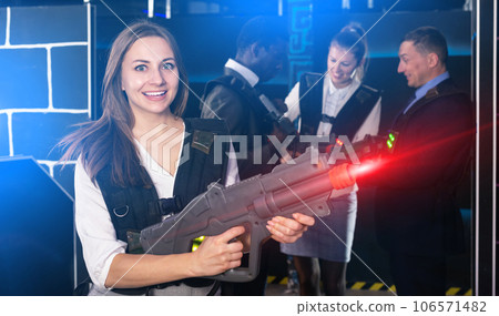 Woman playing lasertag with co-workers 106571482