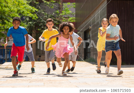Team of positive kids running in race in the street and laughing 106571503