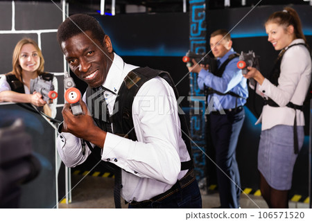 African American with laser gun playing laser tag 106571520