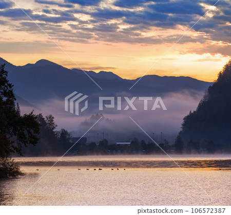 Peaceful autumn Alps mountain lake. Sunrise Wolfgangsee lake view, St. Wolfgang im Salzkammergut, Upper Austria. Peaceful autumn Alps mountain lake. Sunrise Wolfgangsee lake view, St. Wolfgang im Salzkammergut, Upper Austria. 106572387