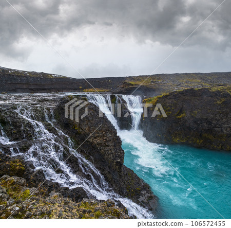 Picturesque waterfall Sigoldufoss autumn view. Season changing in southern Highlands of Iceland. 106572455