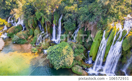 Aerial view of Kravica karst forest waterfall streams with lake in the foreground, Trebizat river, Bosnia and Herzegovina Aerial view of Kravica karst forest waterfall streams with lake in the foreground, Trebizat river, Bosnia and Herzegovina 106572931