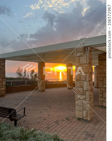 View of a beautiful sunset and a stone canopy gazebo on the seashore in Netanya View of a beautiful sunset and a stone canopy gazebo on the seashore in Netanya 106572967
