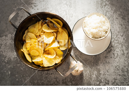 Rice and fried potato slices under the sunlight. 106575880