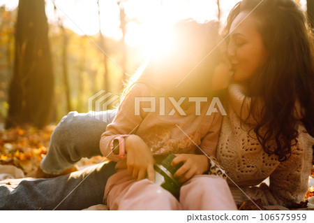 Portrait of happy mother and daughter in autumn forest at sunset. . Autumn women. Portrait of happy mother and daughter in autumn forest at sunset. . Autumn women. 106575959
