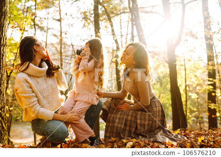 The homosexual family playing with her daughter in the autumn forest. The adventure is more fun. The homosexual family playing with her daughter in the autumn forest. The adventure is more fun. 106576210