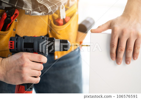 Worker drilling board using mobile drill Worker drilling board using mobile drill 106576591